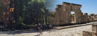 Composite photo showing cyclists at tree-lined New York City intersection and the archaeological remains of an ancient building in Tunisia.