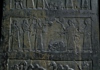 Inscribed black stone surface with cuneiform texts and a group of seven people engaged in ritual performance.