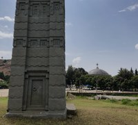 Stone tower with domed building in the background