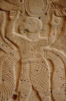 Relief carving from the 8th century BCE depicting a human figure with an animal-like head, arms raised, and detailed attire.