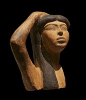 brown statuette of mourner with dark hair on a black background