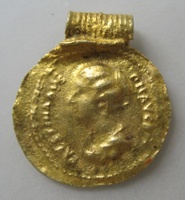 Gold pendant showing a woman looking left with words circling the woman, in imitation of a Roman coin