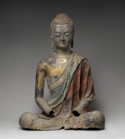 Seated statue of Buddha with some damage, especially to the hands