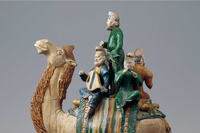 Painted sculpture showing a group of four musicians riding on the back of a saddled camel