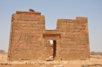 Photo of pylons at front of temple site; reliefs on pylons depict king and queen smiting their enemies.