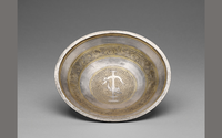 Silver bowl with golden anchor and dolphin medallion.