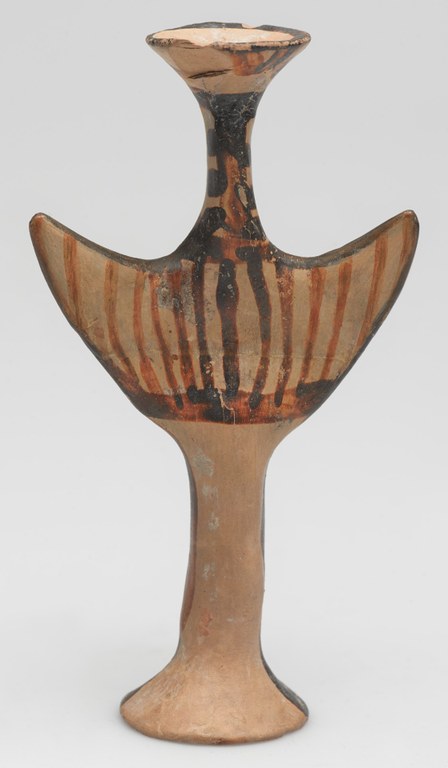 Ceramic figurine in the stylized shape of the Greek letter "Psi" with brown wavy vertical stripes.