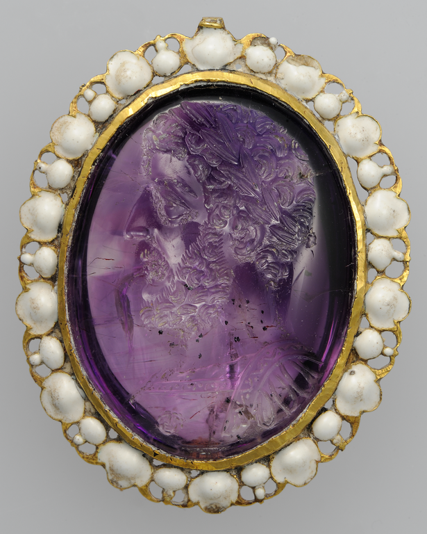 Photograph of an amethyst gem showing a curly-haired, bearded male head in profile with laurel crown.