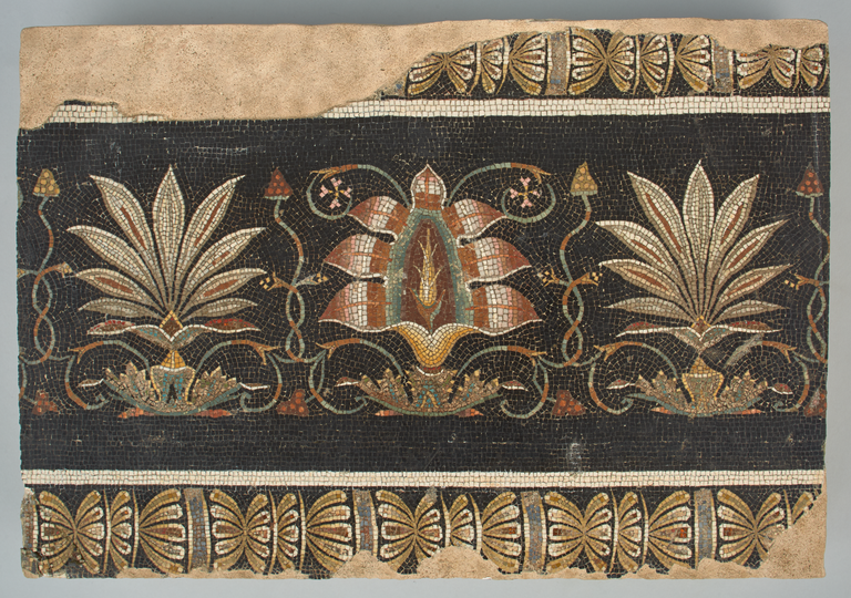 Photograph of a mosaic fragment fashioned from tiny pieces of stone and colored glass to depict a frieze of a flowering lotus and palmettes.