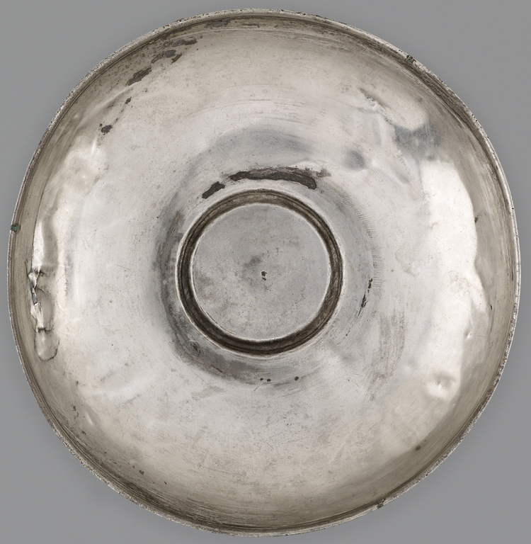 Photograph from above of a silver offering bowl. No figurative decoration is visible.