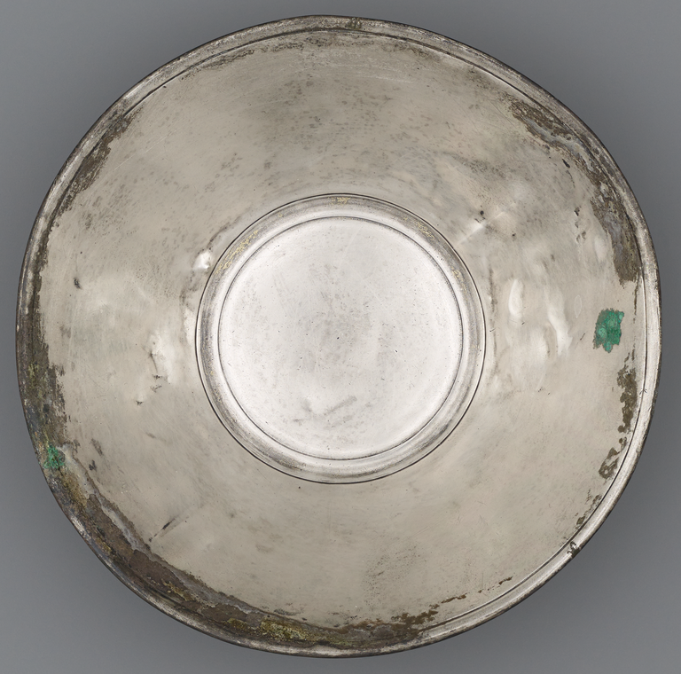 Photograph from above of a silver offering bowl. No figurative decoration is visible.