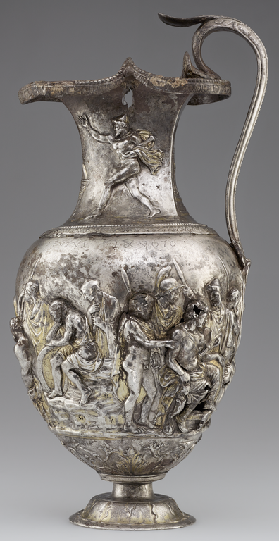 Photograph of a silver and gold pitcher richly decorated with figures in raised relief.