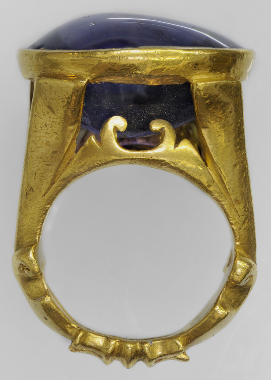 Photograph of a gold ring with a single sapphire.
