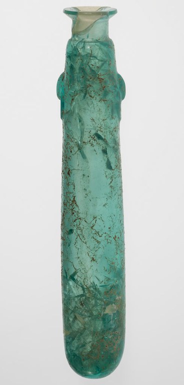 A perfume bottled made with polished glass. The bottle is long in structure with a thin neck and a slightly broad mouth. The bottle is a translucent green in color.