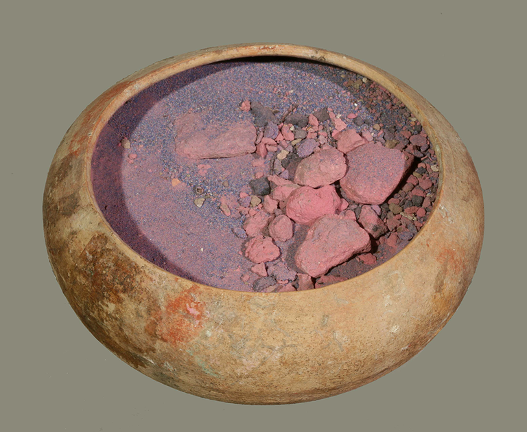 A terracotta bowl with bright-pink pigment in chunks as well as pulverized.
