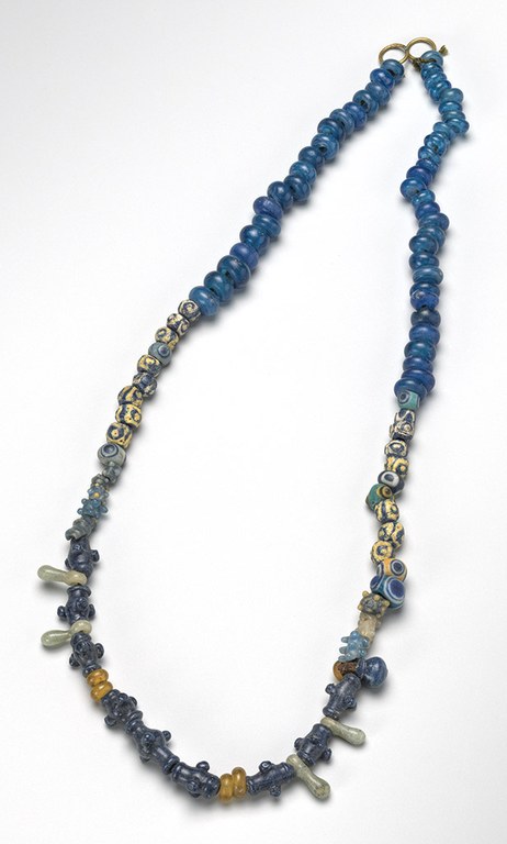 One string of dark-colored beads and a second string of multicolored beads. Each string of beads has a pair of small gold circles for a clasp.