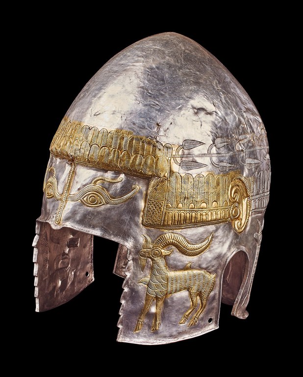 The conical helmet is decorated with eyes and ears, as well as vegetal and geometric designs and a horned animal on the cheekpiece.