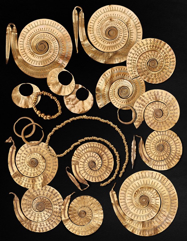 Eleven spiral disks, three crescent-shaped disks, three grooved rings, a ring of large and small beads, and a string of small beads.