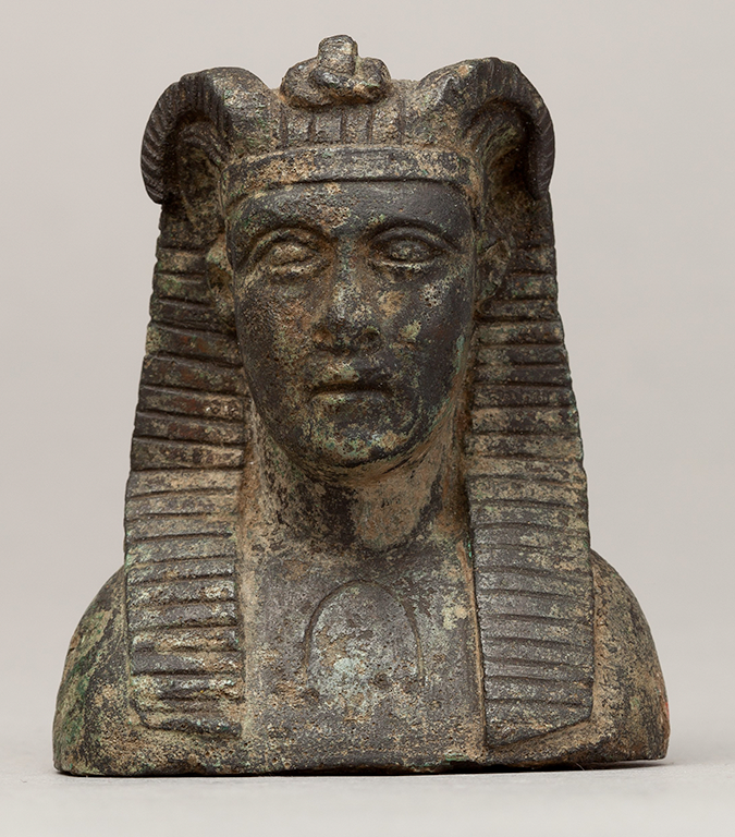 Photograph of a copper alloy figure of Alexander's head and shoulders with Egyptianizing headdress and horns.