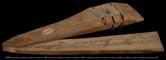a wedge-shaped wooded tablet opened and spread like a fan, revealing writing in ink inside in an ancient Indian script.