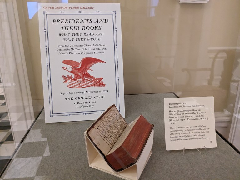 A display case containing Jefferson's copy of the Iliad, before a sign advertising the exhibition "Presidents and Their Books." 