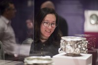 Woman looking at silver object in display case