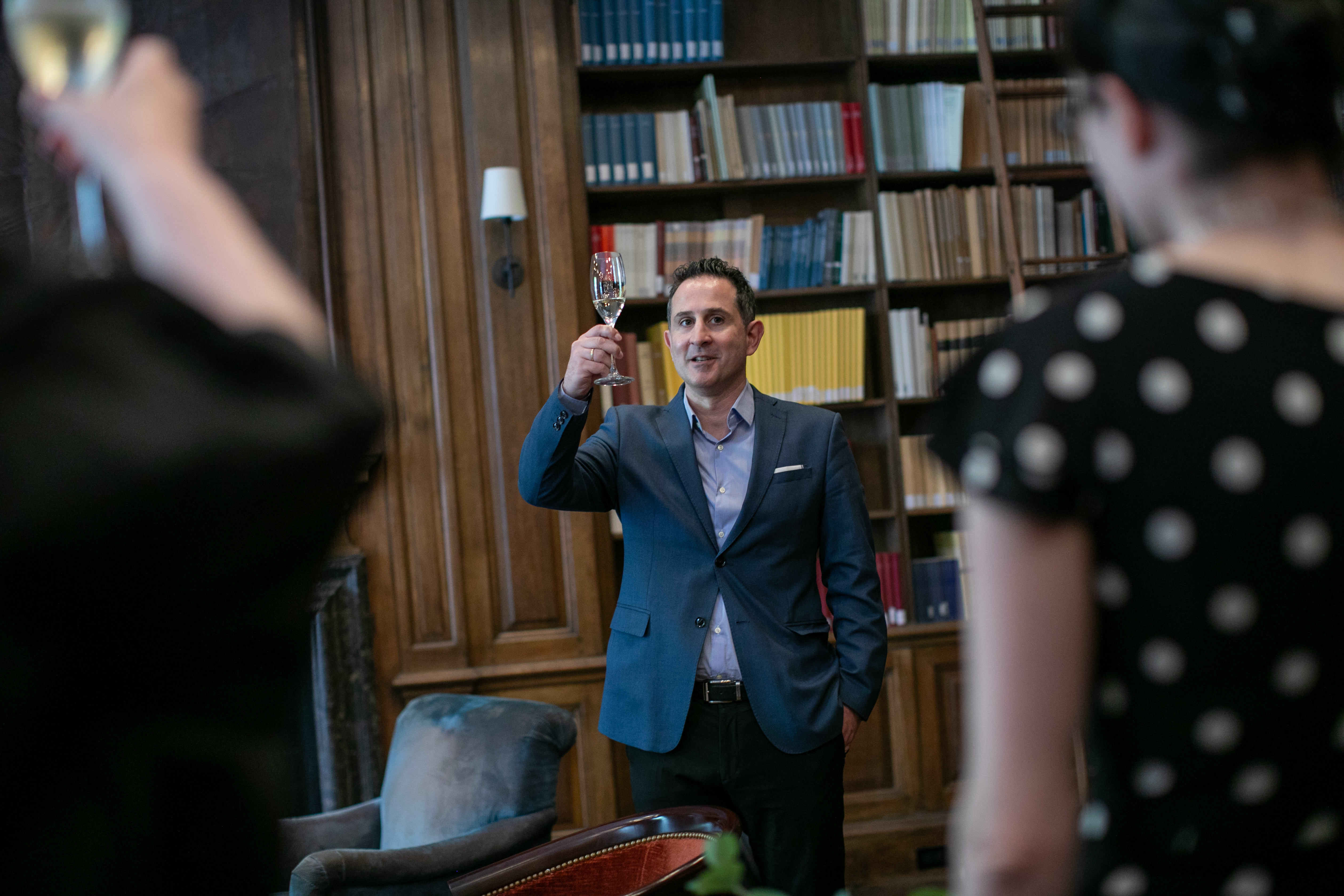 photo of individual raising a glass as if about to give a toast