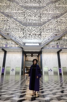 Fanghan Wang in a cap and gown in Bobst Library.