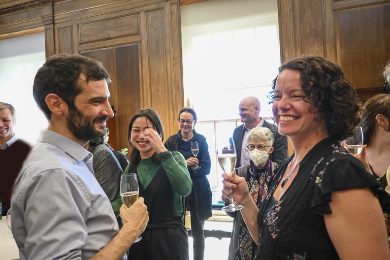 Members of ISAW community lifting their champagne glasses for a toast with one of the graduates and a friend in the foreground