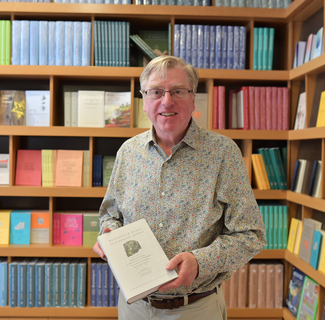 ISAW Director Alexander Jones holding the Greek translation of his publication, 'A Portable Cosmos'. 