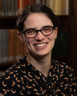 Headshot of Professor Claire Bubb against a background of a library shelf