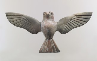 Ivory statue of hawk facing viewer with outspread wings