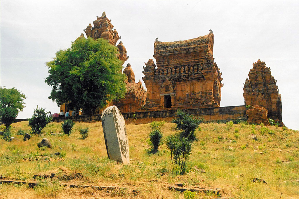 Photograph of the stela bearing the unfinished inscription , with the temple of Po Klaong Girai in the background. Taken by William Southworth on .