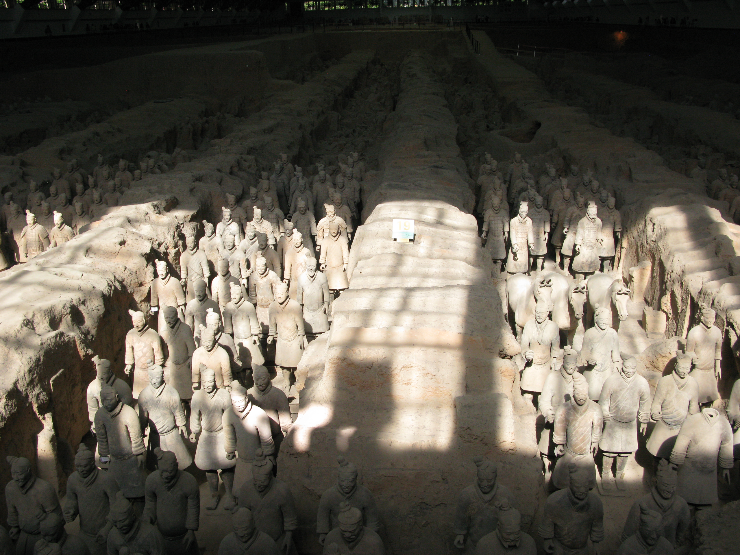 Parts of six trenches, with earth balks between, can be seen in a photo. In the trenchs are gruops of ceramic soldiers, standing 4-5 wide in each trench. In one trench, ceramic statues of two horses can also be seen.