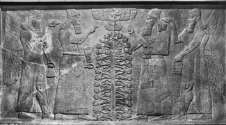 A black and white photo depicts a stone engraving showing two bearded individuals on each side of a stylized plant or tree atop which a winged and tailed symbol is carved. Each of the outer figures also has wings. Indistinct text covers the area from the figures' waists to their knees.