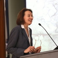 Woman stands at podium with microphone