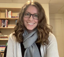 woman with glasses wearing a cardigan and scarf