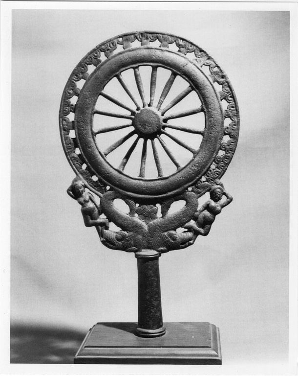 Spoked wheel finial supported by two makaras and two female figures on a bronze rod